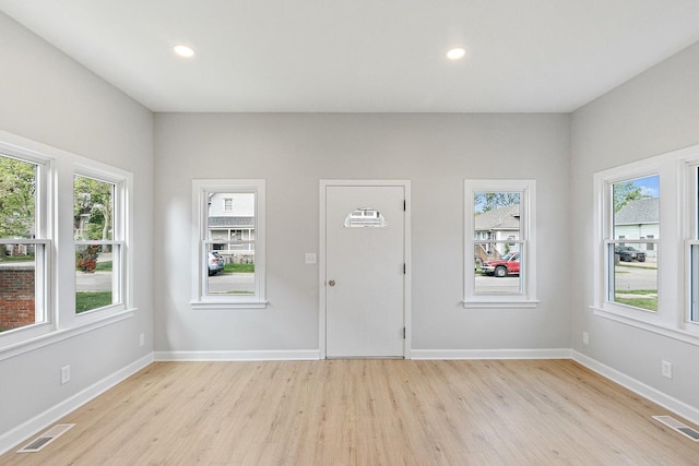 foyer entrance with light wood-style floors, healthy amount of natural light, baseboards, and recessed lighting