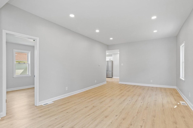 unfurnished room with light wood finished floors, recessed lighting, and baseboards