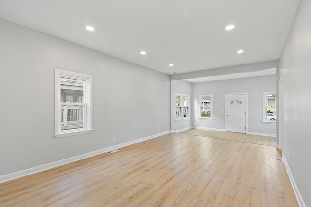 unfurnished living room with recessed lighting, light wood-style flooring, and baseboards