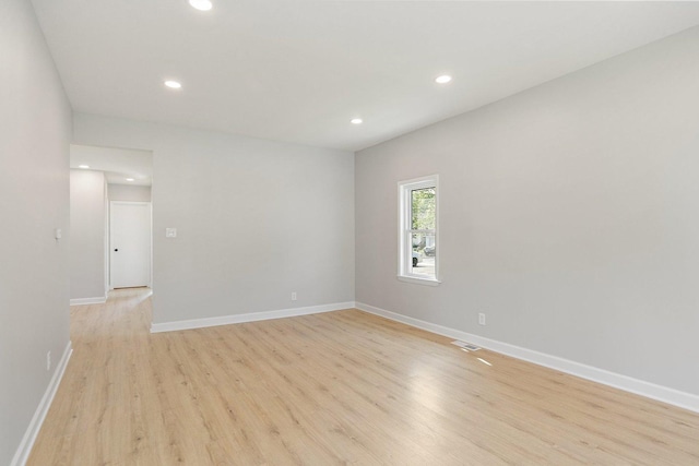 spare room with light wood-type flooring, recessed lighting, and baseboards