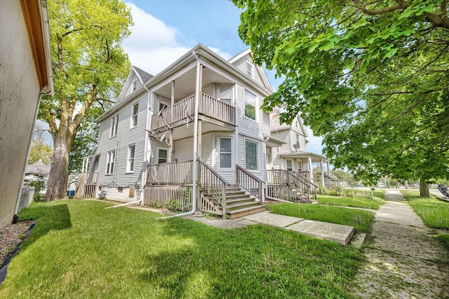 view of front of home featuring a balcony and a front lawn