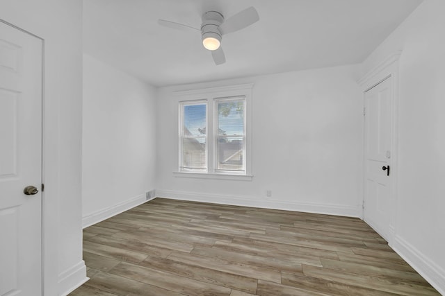 unfurnished bedroom with wood finished floors, baseboards, and a ceiling fan