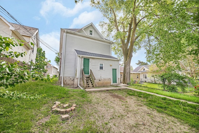 back of house featuring entry steps and fence
