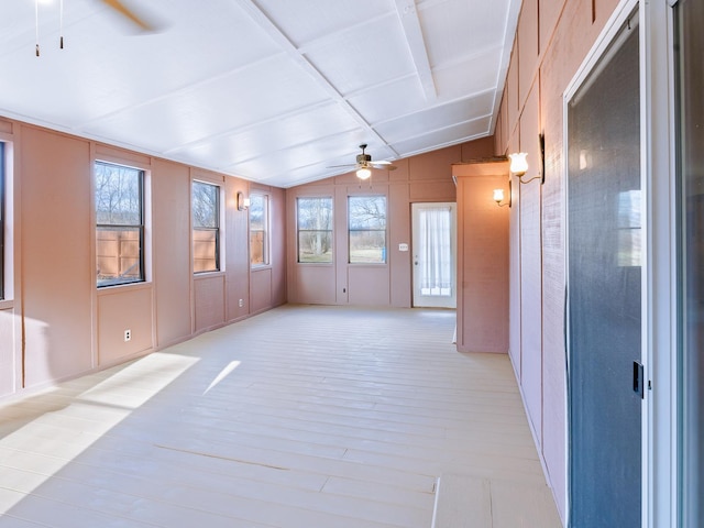 unfurnished living room featuring a ceiling fan, light wood-type flooring, and a decorative wall