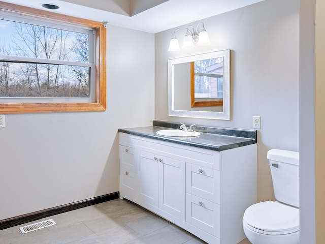 bathroom featuring toilet, vanity, and tile patterned flooring
