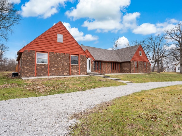 view of front facade featuring brick siding and a front yard