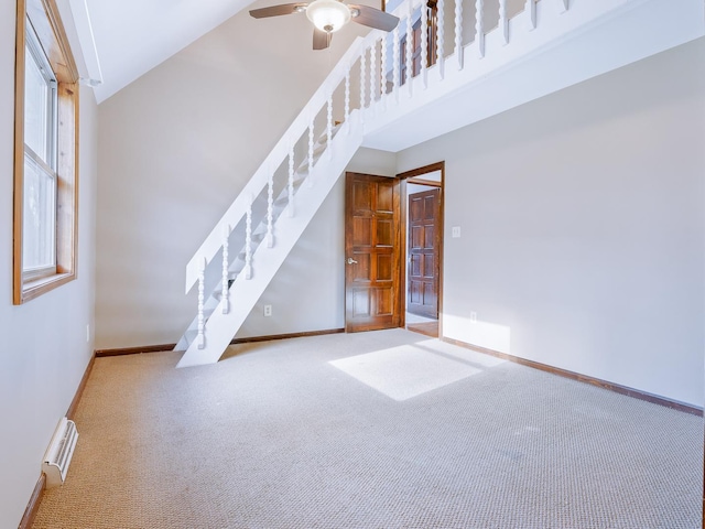 unfurnished living room featuring carpet floors, stairway, a ceiling fan, baseboards, and a towering ceiling