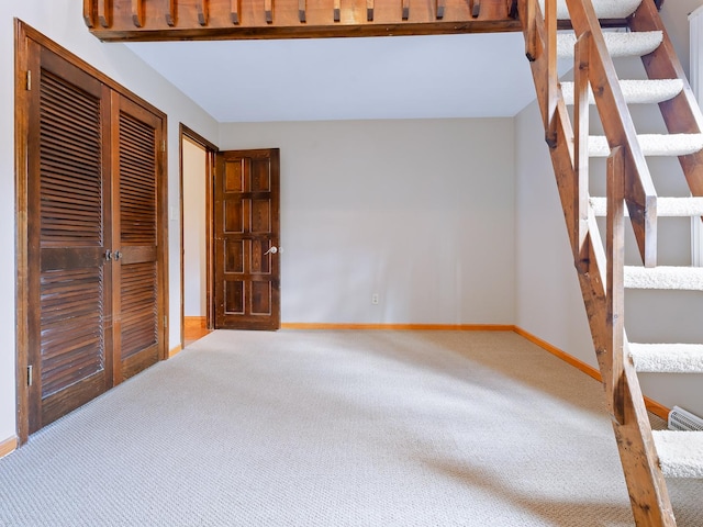 unfurnished bedroom featuring carpet floors, baseboards, and a closet