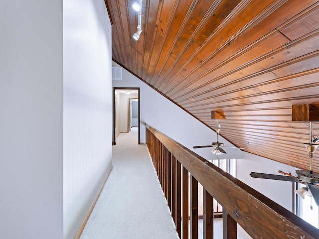 corridor with wooden ceiling, lofted ceiling, carpet, and baseboards