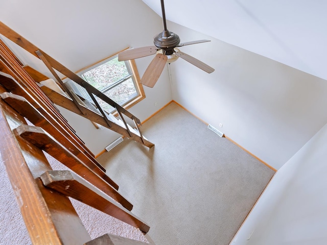 staircase with ceiling fan, lofted ceiling, carpet, and baseboards