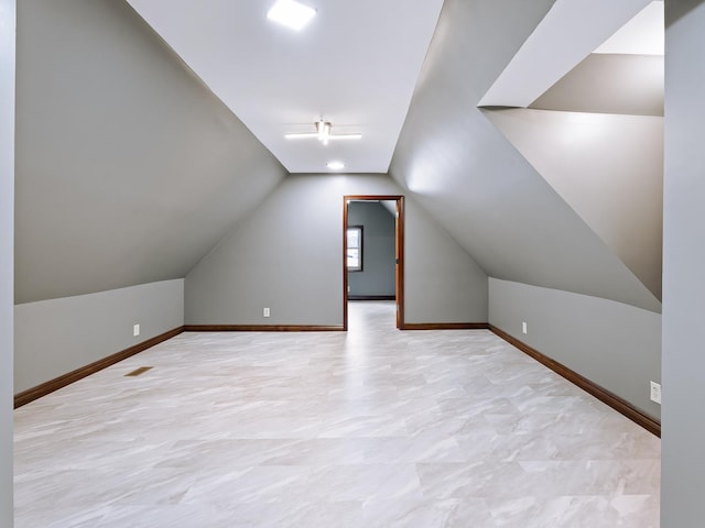 bonus room featuring vaulted ceiling, baseboards, and a ceiling fan