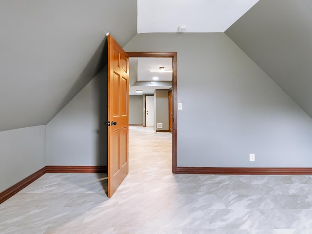 additional living space featuring lofted ceiling and baseboards