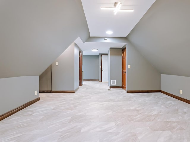 additional living space with vaulted ceiling and baseboards
