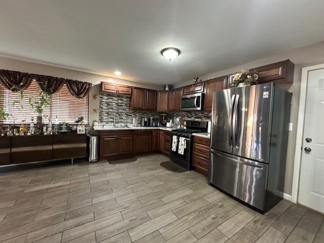 228 Janes Ave, Bolingbrook, IL 60440 - kitchen featuring appliances with stainless steel finishes, light countertops, tasteful backsplash, light wood finished floors, and a sink