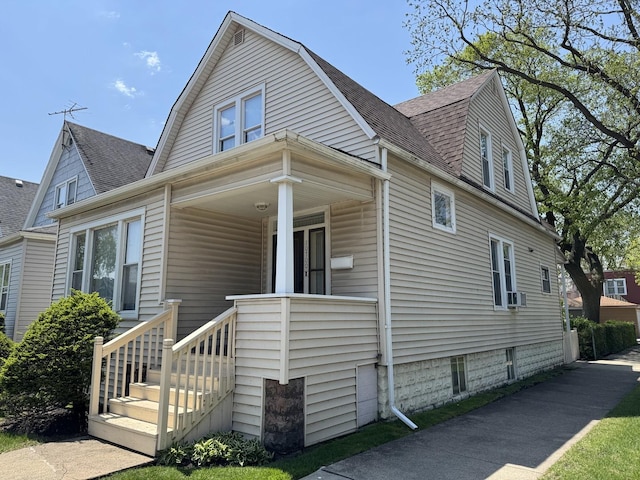 dutch colonial featuring roof with shingles, a gambrel roof, and cooling unit