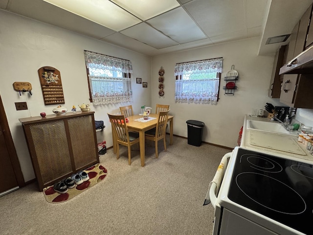 dining space featuring light colored carpet and baseboards