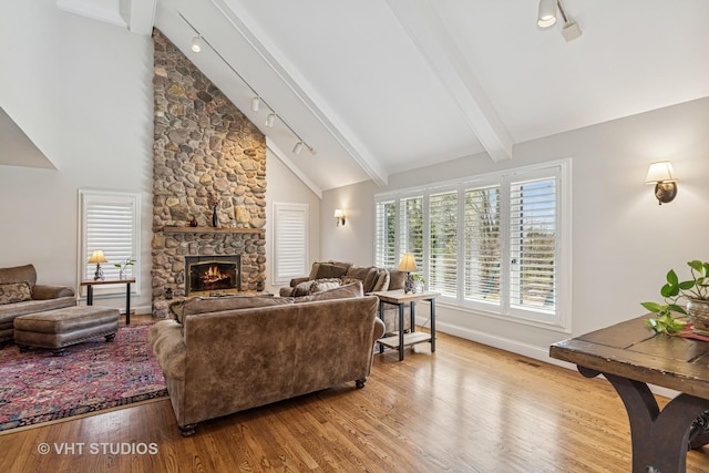 3937 Lakeview Ct, Long Grove, IL 60047 - living area with track lighting, wood finished floors, beam ceiling, a stone fireplace, and baseboards