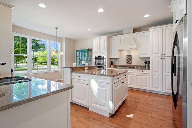 2904 Portage St, Naperville, IL 60564 - kitchen featuring stainless steel appliances, custom exhaust hood, a sink, light wood-style floors, and white cabinets