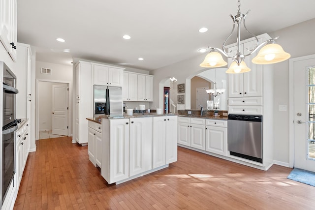 2904 Portage St, Naperville, IL 60564 - kitchen featuring appliances with stainless steel finishes, arched walkways, light wood finished floors, white cabinets, and recessed lighting
