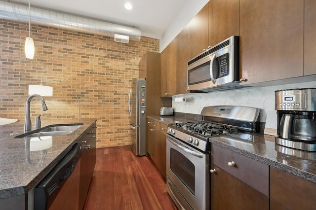 3133 N Lakewood Ave Unit 3I, Chicago, IL 60657 - kitchen with appliances with stainless steel finishes, a sink, dark wood-style floors, dark stone countertops, and brick wall
