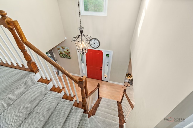 5538 Prairiemoor Ln, Long Grove, IL 60047 - stairs featuring a chandelier, wood finished floors, a high ceiling, and baseboards