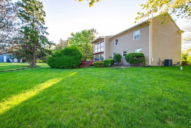 5538 Prairiemoor Ln, Long Grove, IL 60047 - rear view of house with central AC unit, a lawn, and a deck