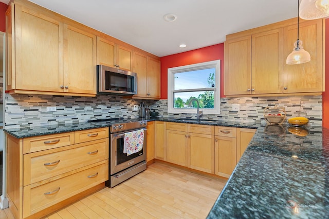 5538 Prairiemoor Ln, Long Grove, IL 60047 - kitchen with appliances with stainless steel finishes, a sink, light wood-style floors, dark stone countertops, and decorative backsplash