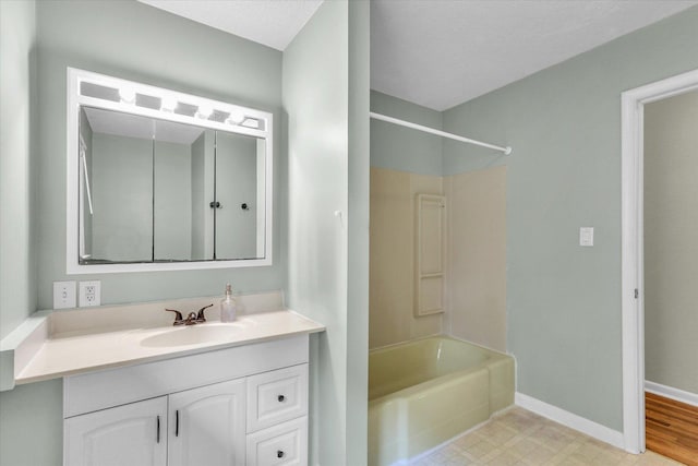 full bath with washtub / shower combination, vanity, and baseboards
