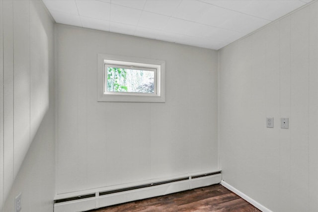 spare room with baseboard heating and dark wood-style floors
