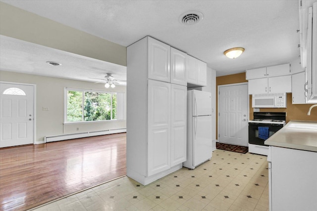 kitchen featuring white appliances, a baseboard heating unit, light floors, and a sink