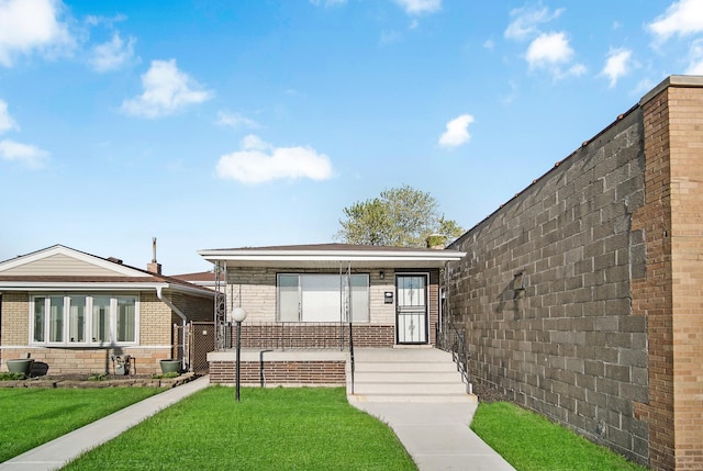 8851 S State St, Chicago, IL 60619 - view of front of house featuring brick siding, a front yard, and covered porch
