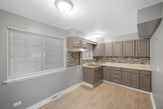 8851 S State St, Chicago, IL 60619 - kitchen with gray cabinetry, decorative backsplash, light wood finished floors, light countertops, and baseboards