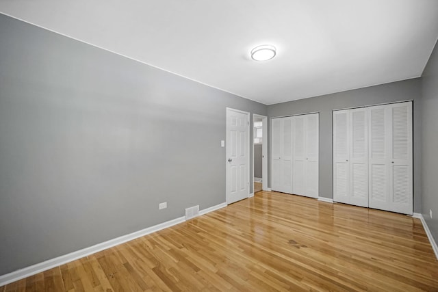 8851 S State St, Chicago, IL 60619 - unfurnished bedroom featuring multiple closets, light wood-style flooring, and baseboards