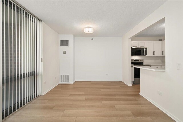 480 N Mcclurg Ct Unit 520, Chicago, IL 60611 - spare room featuring light wood finished floors, a textured ceiling, and baseboards