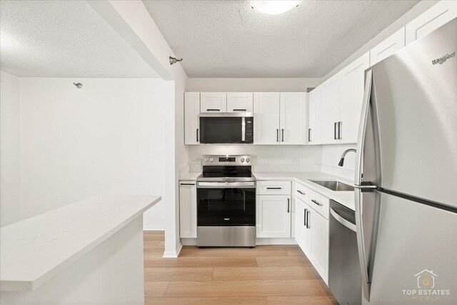 480 N Mcclurg Ct Unit 520, Chicago, IL 60611 - kitchen featuring stainless steel appliances, a sink, a textured ceiling, light wood-style flooring, and white cabinetry