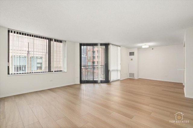 spare room with light wood-style floors and baseboards