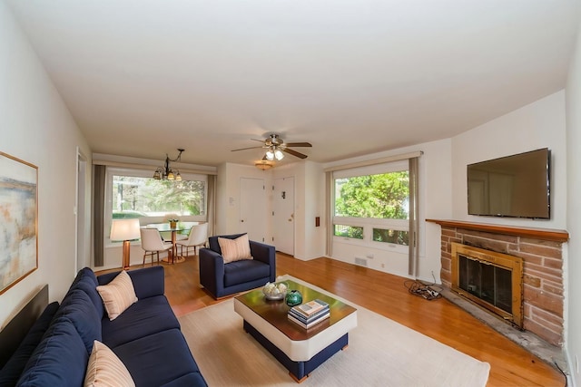 1727 Dundee Rd, Northbrook, IL 60062 - living room featuring a stone fireplace, plenty of natural light, light wood-style flooring, and ceiling fan