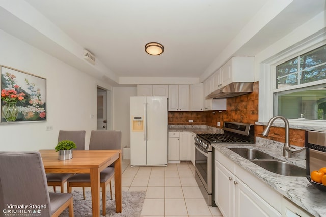 1727 Dundee Rd, Northbrook, IL 60062 - kitchen with white refrigerator with ice dispenser, stainless steel range with gas stovetop, under cabinet range hood, a sink, and backsplash