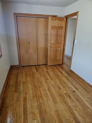 unfurnished bedroom with light wood-style floors, baseboards, and a closet