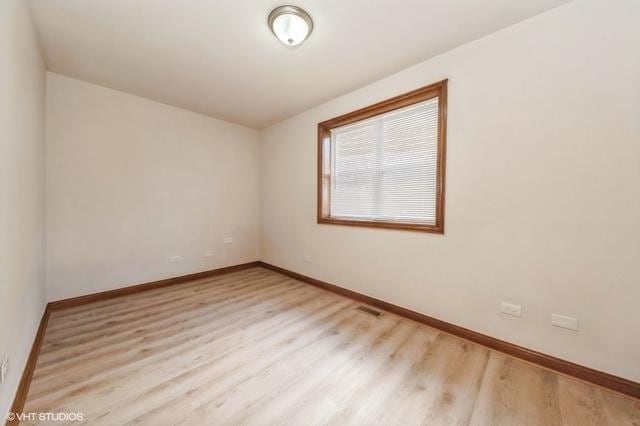 unfurnished room with baseboards and wood finished floors