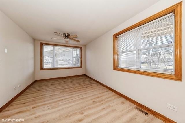 unfurnished room featuring baseboards, a ceiling fan, and light wood-style flooring
