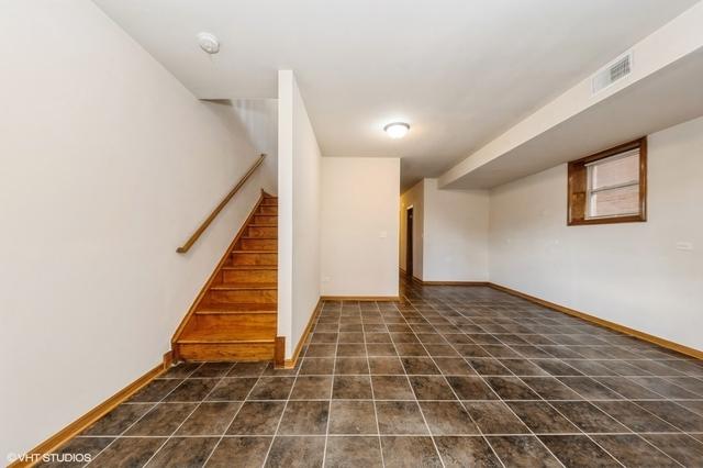 finished below grade area featuring stairs, baseboards, and dark tile patterned floors