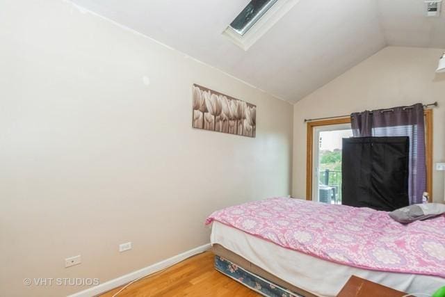 bedroom with lofted ceiling, baseboards, and wood finished floors