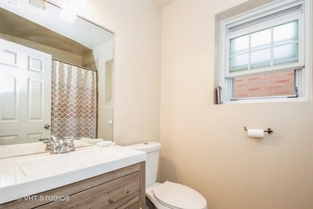 bathroom featuring toilet, vanity, and a shower with curtain