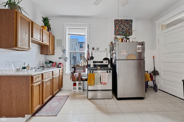 3310 S Lowe St, Chicago, IL 60616 - kitchen with stainless steel appliances, brown cabinetry, a sink, light countertops, and light tile patterned floors