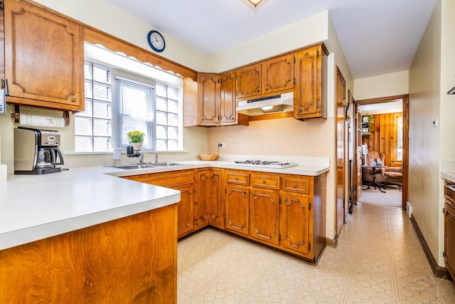 3730 Wenonah Ave, Berwyn, IL 60402 - kitchen with under cabinet range hood, a sink, brown cabinetry, light countertops, and light tile patterned flooring