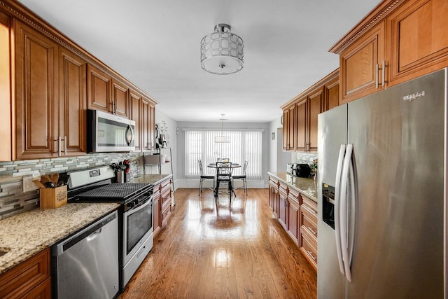 1636 S 14th Ave, Maywood, IL 60153 - kitchen featuring appliances with stainless steel finishes, brown cabinetry, light wood-type flooring, and decorative backsplash