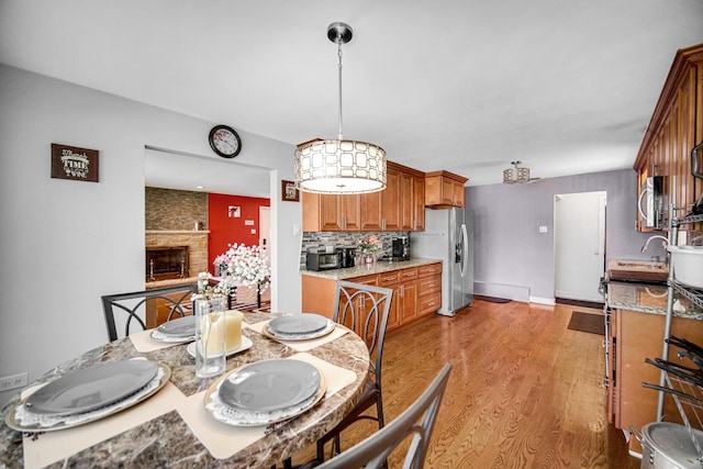 1636 S 14th Ave, Maywood, IL 60153 - dining space featuring light wood finished floors, a fireplace, and baseboards