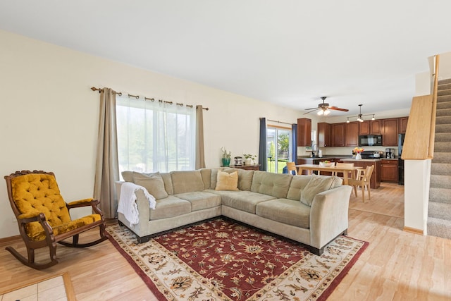 223 Aspen Cir, Gilberts, IL 60136 - living room with stairway, light wood-style floors, ceiling fan, and baseboards