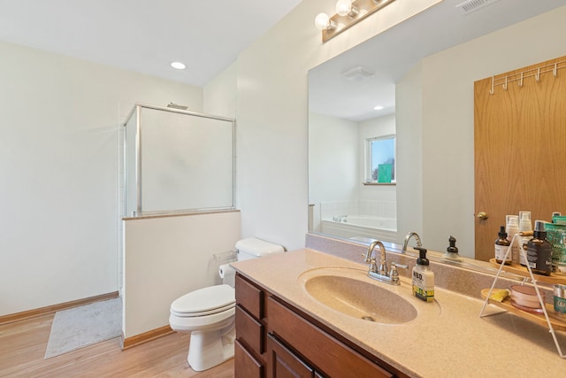 223 Aspen Cir, Gilberts, IL 60136 - full bathroom with a stall shower, toilet, wood finished floors, a garden tub, and vanity